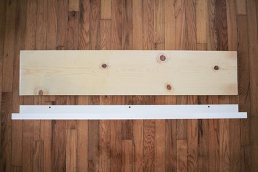 Plain plywood piece resting on wood flooring next to upright white wood piece