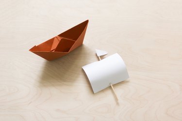 Folded brown paper boat with sail made from paper and a toothpick