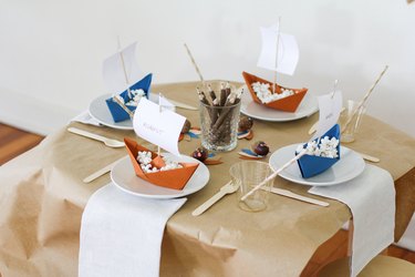 Kids table with folded boat decorations and disposable dishware