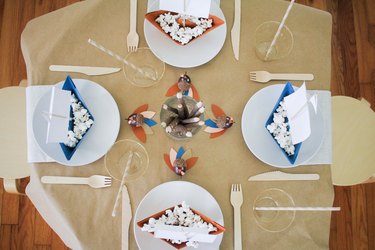Kids table with paper tablecloth, disposable dishware, and paper decorations