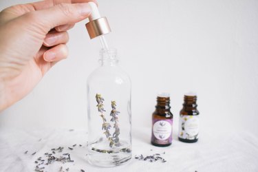 Spray bottle with herbs and essential oil bottles