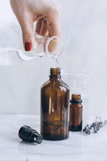 adding alcohol to essential oils in a spray bottle