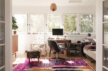 white home office with desk and chair in front of windows