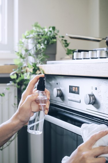 using  spray bottle to clean a stainless steel oven with water and rubbing alcohol