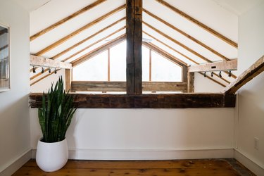 a triangular window under a sloped, half-timbered ceiling