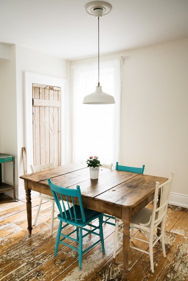 a dining table in a room with a wood floor, both made from wide rustic planks