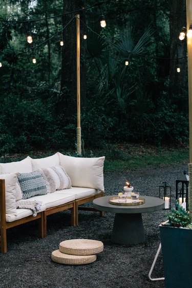 Patio furniture with coffee table and string lights on wood poles