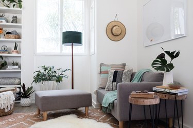 Gray-white furniture in a living room with plants and turquoise, brown accents