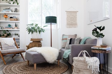 Gray-white furniture in a living room with plants and Boho decor.