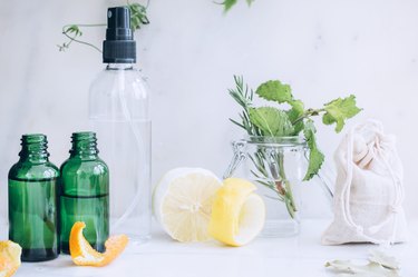 lemon, lemon peel, spray bottles, and mint leaves in a jar