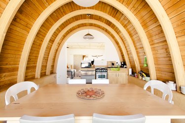 a dining room with curving wooden walls and ceiling that look like a ship's hull