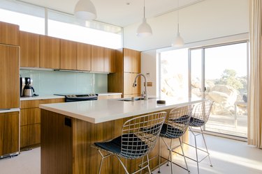 midcentury bar stools with metal mesh seats at a kitchen island