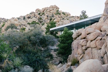 a corner of the house visible behind a wall of boulders