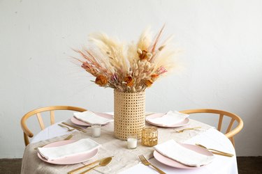 Cane vase with dried flowers on dining room table