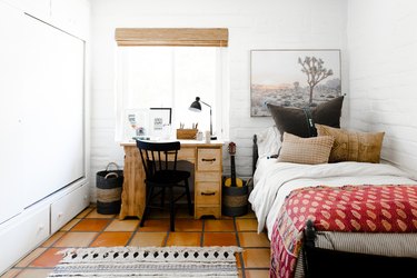 home office in kids bedroom with small wood desk in front of window