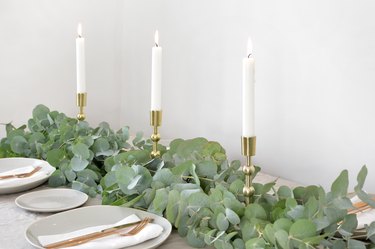 a table runner made from bunches of eucalyptus branches studded with tapers