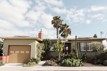 Front of midcentury home with palm trees