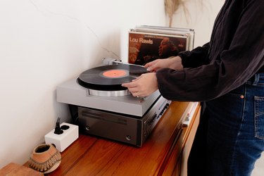 Woman placing record on record player