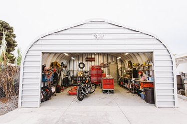 White garage with motorcycle, storage cabinets, and shelving