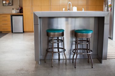 Two vintage turquoise seat bar stools at a steel or metal kitchen island.