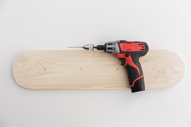 Curved wood board with screws and a power drill