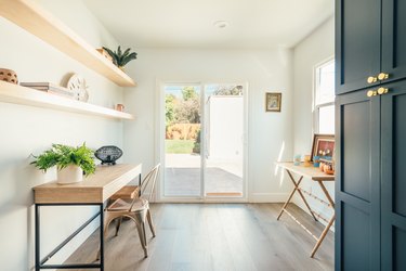 Plants on a wood desk and shelving and a bar with shot glasses and Moscow mule mugs