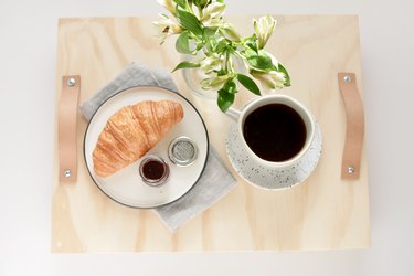 breakfast items on a tray made from plywood with leather strips for handles