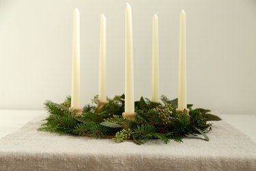 Table wreath with assorted greenery and white candlesticks