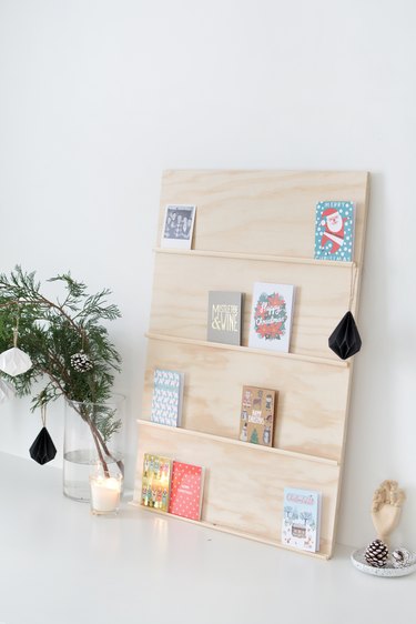 holiday cards sit on shelves made from thin strips of moulding glued to a plywood sheet