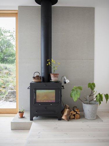 a wood-burning stove on a concrete pad indoors