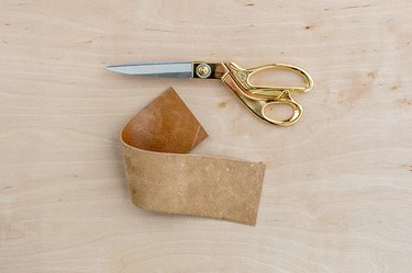a wide strip of leather and scissors