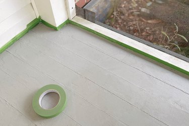 Painted gray sunroom floor, with painter's tape on the edges