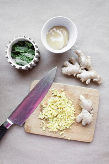 minced ginger on a cutting board surrounded by bows of mint and glycerine