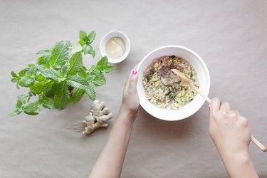 stirring wet and dry ingredients together in a bowl with a wooden spoon