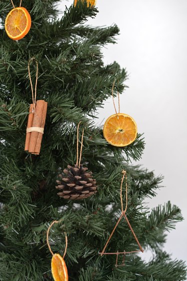 Tree with ornaments made from dried orange slices, pinecones, twigs and cinnamon sticks