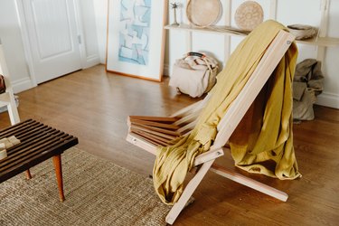 Boho living room with yellow blanket tossed on wooden chair