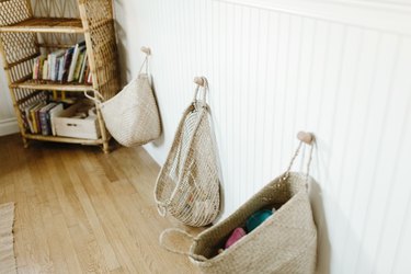 Natural white baskets hanging on white wainscoating walls