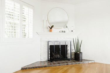 A white living room with a fireplace and interior shutters