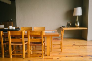 Mid-Century wood dining table set on wood flooring, a corner side table with a lamp