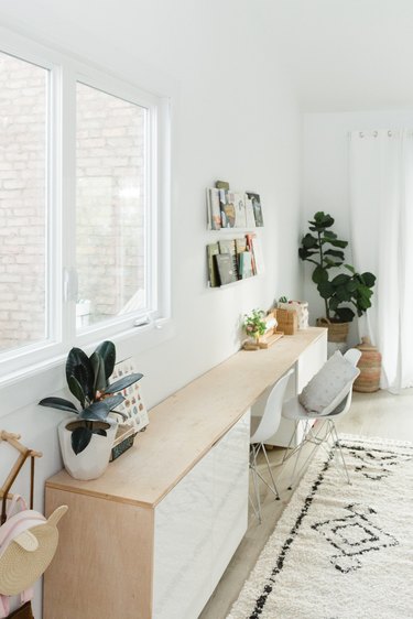 Long white and wood dresser in boho room with fiddle fig plant