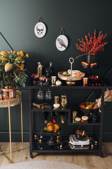 Bar cart with gold dishware and autumnal floral, pumpkin decor