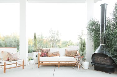 Outdoor patio with white boho furniture and black fireplace