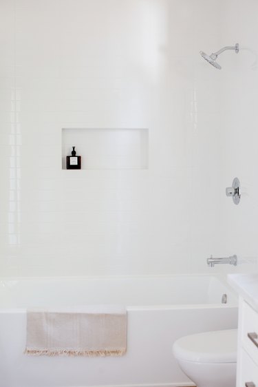 Bathroom with white walls, white tub, white toilet.