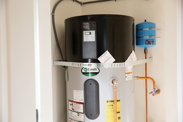 Closeup of a Smith brand water heater in a small white room.