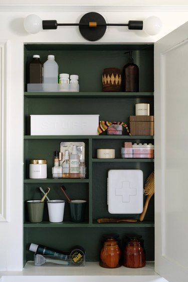 Forest green medicine cabinet with toiletries