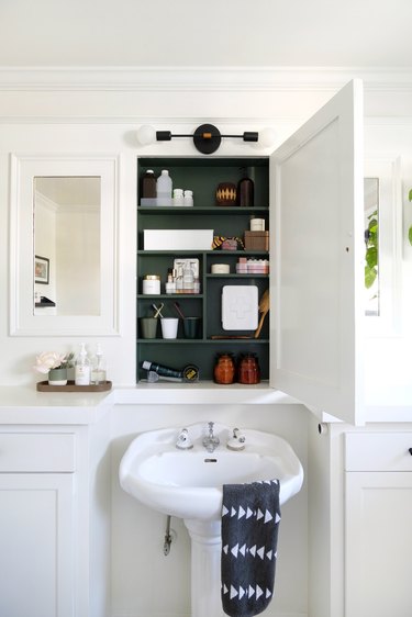 Pedestal Sink Storage Ideas in White walled bathroom with forest green medicine cabinet over porcelain sink