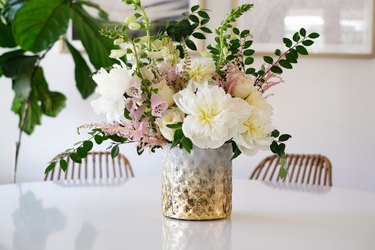 Textured vase with white and pink flowers with green leaves