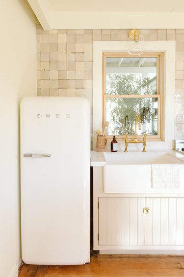 white Smeg refrigerator and farmhouse sink