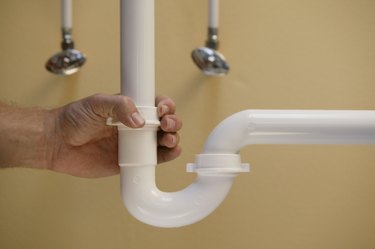 Person adjusting plumbing pipe
