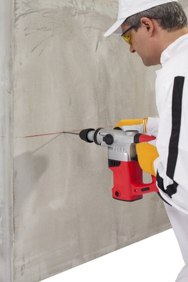 Worker making hole with a perforator